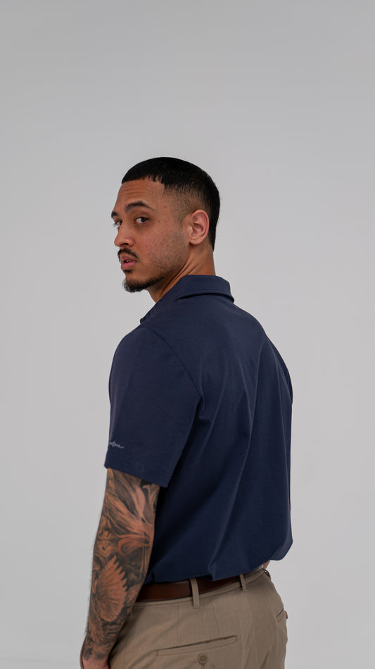 Le Classique Polo in navy, worn on model, back three-quarter view
