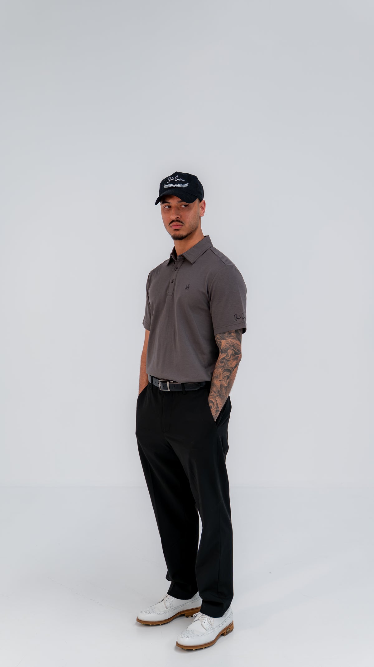 Le Classique Polo in charcoal styled with black trousers, full-length view