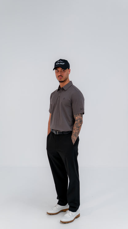 Le Classique Polo in charcoal styled with black trousers, full-length view