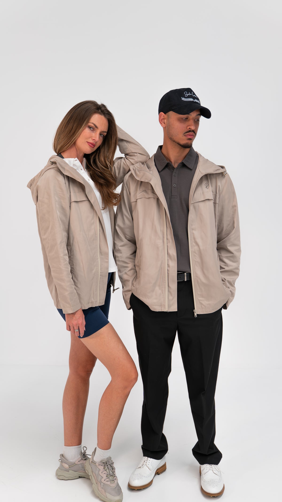 Two models wearing The Shelter packable rain jacket in sand
