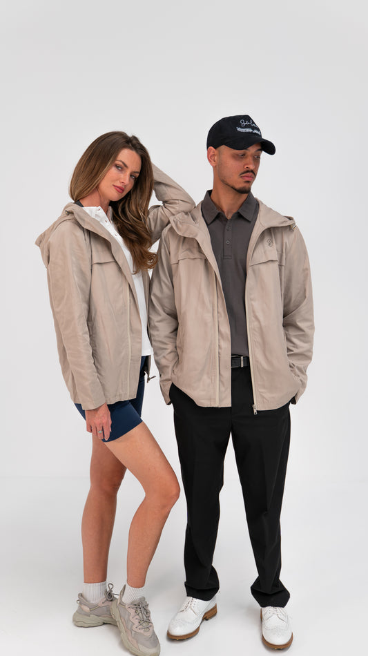 Two models wearing The Shelter packable rain jacket in sand