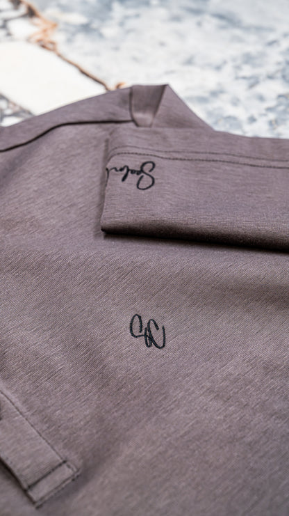 Le Classique Polo in lilac, close-up of embroidered monogram and sleeve signature